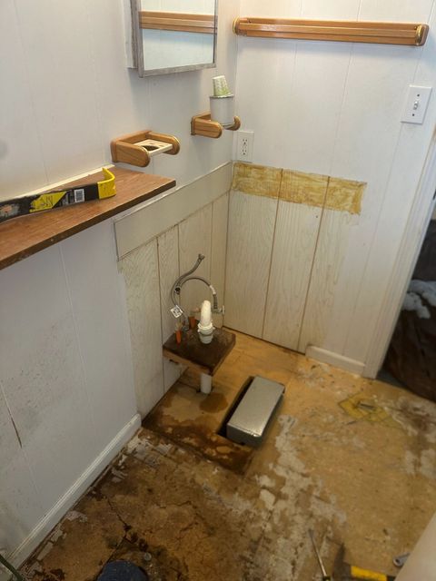 Bathroom vanity removed and wall paneling opened up during the update
