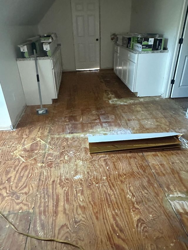 Upstairs kitchenette with bare plywood subfloor before new flooring, Howard City