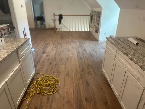 New wood-look vinyl plank floor installed between kitchen cabinets